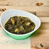 This traditional dish features a hearty blend of shredded leafy vegetables, such as shredded afang leaves and spinach, cooked in a savory sauce made from palm oil, smoked shrimp & fish, and spices.