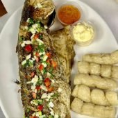 A fresh whole redfish is expertly seasoned and grilled to perfection, showcasing the natural sweetness and delicate texture of this delectable fish.